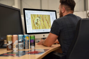 A Can Designer working on artwork.